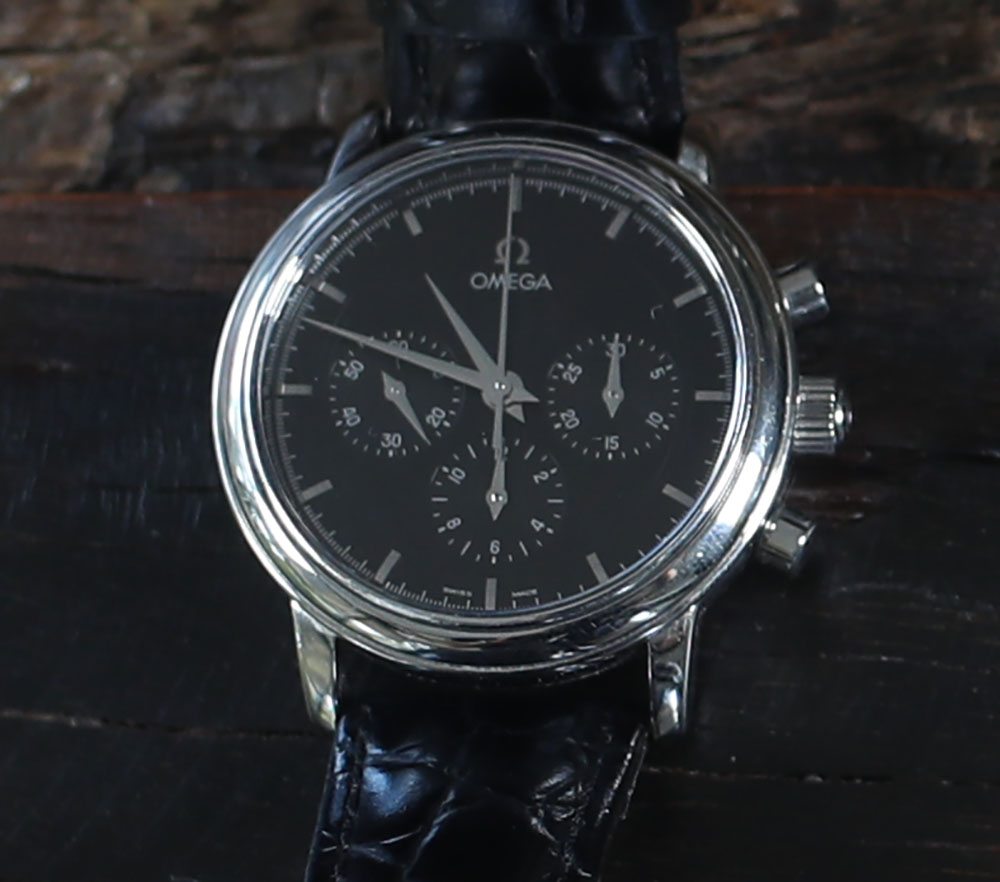 An Omega Chronograph with black band and polished chrome.