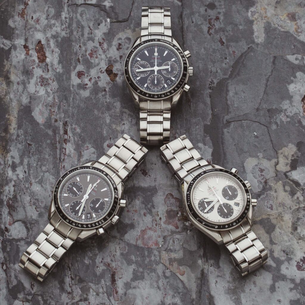 a trio of speedmaster watches on slate 